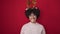 Young african american woman smiling confident wearing christmas reindeer ears over isolated red background