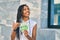 Young african american woman smiling happy counting norwegian 50 krona banknotes at the city