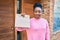 Young african american woman smiling happy holding delivery paper bag with take away food at the city