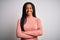 Young african american woman standing casual and cool over white  background happy face smiling with crossed arms looking