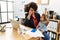 Young african american woman talking on the smartphone working with baby at office