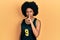 Young african american woman wearing basketball uniform asking to be quiet with finger on lips