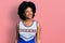 Young african american woman wearing cheerleader uniform looking away to side with smile on face, natural expression