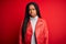 Young african american woman wearing cool fashion leather jacket over red isolated background skeptic and nervous, frowning upset