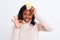 Young african american woman wearing pretend queen crown over isolated background doing ok sign with fingers, excellent symbol