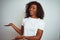 Young african american woman wearing t-shirt standing over isolated white background Inviting to enter smiling natural with open