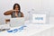 Young african american woman working at political election sitting by ballot doing time out gesture with hands, frustrated and