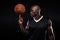 Young african athlete balancing basketball on his finger