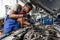 Young African auto mechanic checking car engine under the hood in auto service