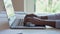 Young African black female hands typing on laptop computer keyboard.