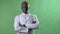 Young african blond doctor in white coat and glasses looking at camera, standing alone on chromakey background