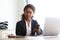 Young african business woman sitting at her desk and reviewing documents