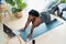 Young African curvy woman doing pilates virtual fitness class with laptop at home