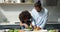 Young African dad and cute little daughter preparing vegetarian salad