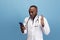 Young african doctor, therapeutic or medical advisor posing  on blue studio back ground. Funny meme emotions