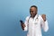 Young african doctor, therapeutic or medical advisor posing isolated on blue studio back ground. Funny meme emotions