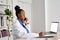 Young african female doctor physician holding phone talking on mobile at work.