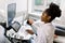 Young African female doctor using ultrasound machine in clinic, makes abdominal ultrasound for pregnant woman patient