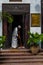 young african guy in national dress sweeps near the hotel entrance