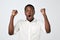 Young african man celebrating victory over gray background