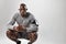 Young african man crouching on grey background