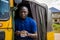 young african man driving a rickshaw taxi counting his money smiling