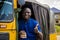 young african man driving a rickshaw taxi counting his money smiling giving a thumbs up