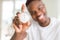 Young african man holding silver retro stopwatch counting time