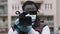 Young african man holding video camera with medical gloves. Reporting about covid19 spread