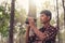 Young African man looking through binocular in the forest, Travel concept.