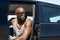 Young african man sitting in car looking away