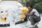 Young African man washing wheels of his luxury car spraying the foam with high pressure .