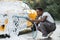 Young African man washing wheels of his luxury car spraying the foam with high pressure .