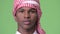 Young African man wearing traditional Muslim clothes against green background