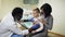 Young african pediatrician checking lung of little boy using stethoscope in the office.