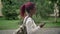 Young African woman with backpack holding phone and going to university, student with pink dreadlocks