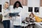 Young African woman doctor explaining results of lungs tomography x-ray image of teen girl to her worried mother, while