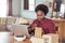 Young African woman labeling packages while working from home