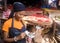 young african woman selling tomatoes in a local african market counting money.