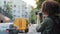 Young African woman tourist with curly hair and backpack travelling, photographing attractions using digital device