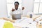 Young african woman working at architecture studio holding house keys smiling happy and positive, thumb up doing excellent and