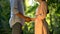 Young afro-american boy tenderly holding girlfriends hands, first date in park