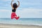 Young afro american dancer jumping on beach