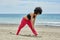 Young afro american sportswoman warming up on beach