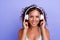 Young Afro American woman athletic physique in a trendy tracksuit. listening to music in wireless headphones