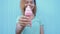 Young afro girl eating pink melting ice cream at blue wall background