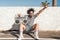 Young Afro Latin man having fun listening music with headphones and vintage boombox during summer vacation