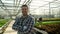 Young agronomist in a greenhouse with growing green salad