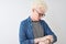 Young albino blond man wearing denim shirt and glasses over isolated white background Checking the time on wrist watch, relaxed