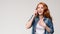 Young amazed redhead woman talking on phone,